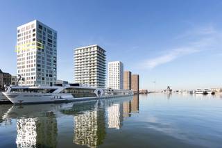 Uitzonderlijk en hoogwaardig ingericht appartement gelegen in Toren 2 van Nieuwbouwproject “Westkaai” met fenomenaal uitzicht over het Eilandje en het dok.<br /><br />Indeling: Inkomhal met toilet en douchecel. Vanuit de hal toegang tot een uiterst zonnige een royale leefruimte met prachtig uitzicht op de bootjes en het MAS. <br />De leefruimte loopt over in een hoogwaardig ingerichte keuken van Bulthaup voorzien van alle toestellen en voldoende opbergruimte. Vanuit de leefruimte heeft men toegang tot een mooi terras met een weids uitzicht. Aansluitend aan de leefruimte een bergruimte met wasmachine. <br /><br />De nachthal geeft toegang tot de hoofdslaapkamer met zicht op de Schelde. Een tweede slaapkamer tevens voorzien van kasten. Royale badkamer voorzien van een douche in bad, dubbele wastafel en een tweede toilet. <br /><br />Ondergrondse autostaanplaats (P2051) te huur aan 150 EUR per maand. <br /><br />Maandelijkse provisie: 200 € (gemeenschappelijke lasten)
