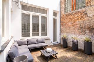 <p>In een charmant en authentiek gebouw bevindt zich dit appartement met terras op de gelijkvloerse verdieping. Gelegen in de Minderbroedersrui bevindt u zich in het hart van het historische centrum van Antwerpen, op wandelafstand van de Grote Markt, de Kathedraal van Onze-Lieve-Vrouw en tal van winkels, restaurants en gezellige cafés. Deze locatie combineert een vlotte bereikbaarheid met een unieke mix van levendige stadsdynamiek en historische charme.</p>
<p>Bij het betreden van het appartement komt u terecht in de lichtrijke leefruimte, die naadloos overgaat in de open keuken, uitgerust met kwalitatieve inbouwtoestellen. Vanuit deze ruimte heeft u bovendien rechtstreeks toegang tot het gezellige terras, waar u in alle rust kan genieten van een aangenaam buitenmoment.</p>
<p>Aan de achterzijde van het appartement bevindt zich een ruime slaapkamer, voorzien van praktische inbouwkasten. Aansluitend vindt u de badkamer, uitgerust met een royale inloopdouche en een dubbele wastafel met voldoende opbergruimte. Aan de voorzijde bevindt zich een tweede kamer, momenteel ingericht als bureauruimte, die zich dankzij haar flexibiliteit perfect leent als kinder- of logeerkamer.</p>
<p>Kortom, een charmant en instapklaar appartement met terras op een toplocatie, ideaal voor wie comfortabel wil wonen in het hart van de stad.</p>
<p>Interesse? Contacteer LISTED voor een bezoek: +32 3 283 51 51.</p>