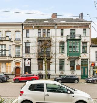 Bij het betreden van deze statige woning naar de hand van architect Jules Taeymans word je meteen verwelkomd in een indrukwekkende inkomhal die naadloos overgaat in een karaktervolle traphal. Op deze verdieping bevinden zich een recent vernieuwde keuken (Interieurstudio Hoskens), een sfeervol salon met hoge plafonds en verfijnde ornamenten, een ruime eetkamer en een lichtrijke tuinkamer die uitkijkt op de tuin.<br /><br />Daarnaast is er een polyvalente hobby- of kantoorruimte met apart sanitair en sauna, rechtstreeks toegankelijk via de inkomhal – ideaal voor ontspanning of professioneel gebruik. Aansluitend vind je de technische ruimte met o.a. de omvormer van de zonnepanelen en de centrale verwarming.<br /><br />Buiten geniet je van een zonnig terras, een gezellige stadstuin en rechtstreekse toegang tot de dubbele garage.<br /><br />Op de verdiepingen bevinden zich maar liefst 7 volwaardige slaapkamers met houten vloeren en 2 badkamers. Deze woning leent zich perfect voor grote gezinnen, co-housing, een combinatie van wonen en werken, of voor wie ruim en comfortabel in het hart van de stad wil wonen.<br /><br />Deze unieke herenwoning biedt uitzonderlijk veel mogelijkheden, zowel voor privébewoning als voor de inrichting van een kantoor of praktijkruimte.<br /><br />Buitengewone troeven:<br />* Tijdloze architectuur gecombineerd met hedendaags comfort, inclusief een dubbele garage met uitrit naar de Molenstraat – een absolute meerwaarde in deze buurt<br />* Energiezuinig dankzij zonnepanelen (2010), conforme elektrische keuring en quasi asbestvrij (enkel één radiatorknop in een slaapkamer)<br />* Centrale ligging nabij winkels, horeca en openbaar vervoer