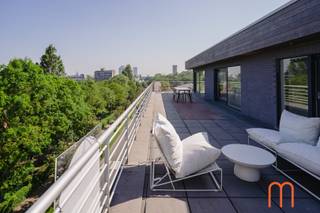 <strong>Une résidence d'exception à la Résidence Tennis Garden</strong><br />Découvrez ce <strong>spacieux penthouse de 128 m²</strong>, situé au <strong>5</strong><strong>ᵉ</strong><strong> étage de la Résidence Tennis Garden à Ostende</strong>.<br />Ce bien unique allie de généreux espaces de vie, d'immenses terrasses et une vue panoramique exceptionnelle.<br />Grâce à son emplacement privilégié, à ses finitions soignées et à son excellent état d'entretien, ce penthouse convient parfaitement comme <strong>résidence principale</strong>, <strong>résidence secondaire</strong> ou <strong>investissement immobilier sur la Côte belge</strong>.<br /><br /><strong>Un espace de vie lumineux et spacieux</strong><br />L'entrée s'ouvre sur un hall avec toilettes invités. Le <strong>séjour lumineux</strong> bénéficie de grandes baies vitrées offrant une abondante lumière naturelle ainsi qu'une vue dégagée à l'avant comme à l'arrière de l'immeuble.<br />Depuis le salon, vous profitez notamment d'une magnifique vue sur les <strong>terrains de tennis d'Ostende</strong>, créant une sensation d'espace et de verdure.<br />La <strong>cuisine ouverte</strong>, parfaitement intégrée au séjour, est complétée par un débarras pratique.<br /><br /><strong>Deux chambres avec salle de bains privative</strong><br />Le penthouse comprend <strong>2 chambres spacieuses</strong>, chacune disposant de sa propre salle de bains :<br /><span>Suite parentale avec salle de bains équipée d'une baignoire.</span><br /><span>Deuxième chambre avec salle de bains équipée d'une douche. </span><br />Cette disposition garantit un confort optimal et une parfaite intimité pour les occupants comme pour leurs invités.<br /><br /><strong>Deux terrasses exceptionnelles totalisant 145 m²</strong><br />L'un des principaux atouts de ce bien réside dans ses <strong>deux vastes terrasses</strong>, représentant une superficie totale d'environ <strong>145 m²</strong>. Situées à l'avant et à l'arrière, elles permettent de profiter du soleil tout au long de la journée ainsi que d'une vue imprenable.<br />es espaces extérieurs prolongent agréablement le séjour et sont parfaits pour se détendre ou recevoir.<br /><br /><strong>Les atouts:</strong><br /><span>Penthouse de <strong>128 m²</strong> + <strong>145 m² de terrasses</strong></span><br /><span>Vue panoramique à l'avant et à l'arrière</span><br /><span>Possibilité d'acquérir <strong>2 garages fermés</strong> dans la résidence</span><br /><span>Installation électrique conforme</span><br /><span>Chauffage électrique (climatisation) + poêle à granulés dans le salon</span><br /><span>PEB :<strong> </strong>en attente</span><br /><span>Année de construction : <strong>2005</strong></span><br /><span>Revenu cadastral : <strong>1.412 €</strong> </span><br /><br /><strong>Pourquoi choisir ce penthouse ?</strong><br />Vous recherchez un <strong>penthouse de standing à Ostende</strong> avec de grandes terrasses, une luminosité exceptionnelle et une vue unique ? Ce bien offre une combinaison rare d'espace, de confort et d'emplacement.<br />La possibilité d'acquérir 2 garages constitue un atout supplémentaire.<br /><br /><strong>Intéressé(e) ?</strong><br />Contactez-nous dès aujourd'hui pour plus d'informations ou pour organiser une visite.<br /> 
