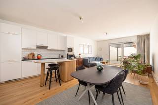 <p><span> </span></p><p><span>Zoek je een instapklaar appartement, met lichte ruimtes, tijdloze materialen, twee slaapkamers en een ruime, zonnige stadskoer? Dan is dit iets voor jou. De toplocatie in Deurne, vlakbij allerlei winkels, openbaar vervoer en parken krijg je er zo bij.</span></p><p><span> </span></p><p><span>In een netjes gerenoveerd, hagelwit gebouw, net tegenover de Albert Heijn, stap je via de gemeenschappelijke inkomhal het gelijkvloers appartement binnen in de centrale hal, waar je een ingemaakte vesitiairekast hebt en alle ruimtes op uitkomen. Bonus: de prachtige parketvloer die je hier ziet, loopt door over het héle appartement! </span></p><p><span> </span></p><p><span>Mega leefruimte en zuiderse tuin-zonder-onderhoud </span></p><p><span>Meteen rechts ga je de lichte leefruimte met open keuken binnen, die je gerust riant mag noemen. Je hebt hier dus heel wat plaats voor een eethoek en een groot salon met zicht op de binnenkoer, die je via het kamerbrede schuifraam op wandelt. De koer heeft een strakke grijze tegel, met aansluiting voor water en elektriciteit. </span></p><p><span>De keukenwand achteraan is tijdloos en praktisch, met z’n witte kastfrontjes, zwart melamine werkblad en spatwand met toffe witte metrotegeltjes. Je hebt hier een elektrisch vuur, dampkap, een spoelbak en een vaatwasser, een ingebouwde koelkast, diepvriezer, oven, microgolfoven, en heel wat kastruimte.</span></p><p><span>Weer in de hal, heb je de nette badkamer, met een prachtige lichtgrijze tegel die werd gebruikt om de hele ruimte te betegelen. Je hebt hier een inloopdouche, een toilet, handdoekendroger en een breed lavabomeubel met grote schuiven. Je hebt hier ook aansluiting voor was en droog met een ingemaakte kast boven.</span></p><p><span>De twee slaapkamers bevinden zich aan de voorzijde, waardoor ze baden in een zee van licht. Extra fijn is hier de warme parketvloer, wat je bed uitkomen meteen een tikje aangenamer maakt…</span></p><p><span> </span></p><p><span>Absolute toplocatie in Deurne</span></p><p><span>Je woont hier op de grens van Borsbeek, Deurne en Wommelgem, op een centrale locatie dichtbij de stad. Het rond punt van Wommelgem met z’n oprit richting E313 en E34 is niet veraf, maar je neemt van hieruit ook makkelijk het openbaar vervoer richting </span><span>’t stad</span><span>. Ook voor groen hoef je nooit ver, want je kunt hier kiezen uit het fort van Borsbeek, het Te Boelaerpark, Boekenbergpark of het mooie Rivierenhof, allemaal op fietsafstand! Slagers, bakkers, apothekers genoeg in de buurt… en zelfs een Albert Heijn aan de overkant van de straat, wat wil je nog meer?</span></p><p><span> </span></p><p><span> </span></p><p><span> </span></p><p><span> </span></p>