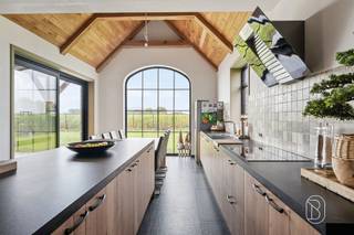 Exclusieve nieuwbouwwoning met 5 slaapkamers, 360 m² woonoppervlakte, toekomstgerichte voorzieningen, en genietend van een prachtig zicht! Bent u op zoek naar een uitzonderlijk ruime en kwalitatieve woning waar comfort, luxe en toekomstgericht wonen centraal staan? Deze in 2023 gebouwde woning biedt maar liefst 360 m² bewoonbare oppervlakte op een perceel van 1.235 m² en werd technisch bijzonder doordacht uitgevoerd.Indeling gelijkvloers: ruime inkomhal, afzonderlijke ruimte ideaal als bureau, apart toilet en een zeer ruime, lichtrijke leefruimte. Aansluitend bevindt zich de luxueuze, volledig geïnstalleerde keuken met hoogwaardige Miele-toestellen, waaronder wijnkoeler, stoomoven, oven, vaatwasser en espressomachine. Verder is er een grote wasruimte met douche en waskoker vanuit de badkamer boven. De inpandige garage biedt plaats aan één wagen, technische installaties en extra stockage.Eerste verdieping: vier slaapkamers, apart toilet en een royale ruimte voorzien voor de inrichting van een wellnessbadkamer, nog volledig af te werken volgens eigen smaak en materiaalkeuze.Zolderverdieping: ingerichte vijfde slaapkamer met verdere afwerkingsmogelijkheden. De voorziene liftschacht loopt door tot deze verdieping.Technisch is de woning bijzonder compleet met vloerverwarming op het gelijkvloers en de eerste verdieping, ventilatiesysteem type D, brede deuropeningen en een liftschacht met bekabeling voor de plaatsing van een inpandige lift.Buiten geniet u van een ruim terras, tuin en meerdere parkeerplaatsen. Bovendien is er een vergunning voor een bijgebouw van 14 m².Een aantal ruimtes dienen nog naar eigen smaak worden afgewerkt, waardoor u zelf de gewenste materialen en inrichting kunt bepalen.Voor wie is dit pand ideaal?♦ Gezinnen die uitzonderlijk veel woonruimte zoeken.♦ Wie comfortabel én toekomstgericht wil wonen.♦ Wie een recente woning verder naar eigen smaak wil afwerken.Een unieke kans voor wie ruimte, kwaliteit en toekomstgericht wooncomfort wil combineren.Bezoek na afspraak met Immo Beguin, jouw vastgoedexpert sinds 2009.Meer info of bezoek via emmy@immobeguin.be
