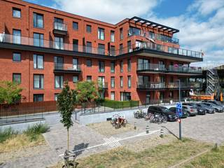 Dit lichtrijk gelijkvloers appartement maakt deel uit van de succesvolle ontwikkeling <em>København</em>. Deze residentie bevindt zich in een wijk die volop in ontwikkeling is en gekenmerkt wordt door nieuwe projecten met een duidelijke opwaardering van de omgeving. Een ligging die het beste van beide werelden combineert: de rust van de Voorhaven en de nabijheid van het stadsleven met vlotte ontsluiting naar de R4 en R40. <br /><br />Het tweeslaapkamer appartement heeft een bewoonbare oppervlakte van 94 m<sup>2</sup> en biedt een zonnig zuidoostelijk gericht terras van liefst 25,8 m<sup>2</sup>. De indeling is als volgt: een inkomhal, een lichtrijke leefruimte ingedeeld in een eet- en zitplaats met rechtstreekse toegang tot het terras en een open keuken. Via de nachthal heeft men toegang tot het toilet, de praktische berging, twee slaapkamers, met beiden toegang tot het terras, en een badkamer voorzien van een inloopdouche en dubbele lavabo.<br /><br />Tot slot dient bij dit appartement een ondergrondse autostaanplaats aangekocht te worden (€ 30.000) en kan men tevens gebruik maken van de gemeenschappelijke fietsenstalling. Het appartement wordt sinds 2024 vlot verhuurd aan een trouwe en correct betalende huurder (€ 1.100/ maand + € 85 provisie gemene lasten). Het appartement wordt verwarmd met radiatoren op aardgas voor een aangename warmte. Daarnaast is het appartement uitgerust met een ventilatiesysteem type C, wat zorgt voor een gezond binnenklimaat.