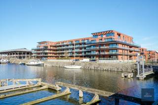 Dit stijlvolle appartement in Gent met twee slaapkamers is gebouwd in het jaar 2020. Het heeft een bewoonbare oppervlakte van 96m² en heeft een mooi terras dat over het water (voorhaven) kijkt. <br /><br />Het appartement is modern en licht ingericht en is voorzien van alle gemakken. De open keuken is voorzien van alle benodigde apparatuur en er is voldoende ruimte om gezellig te kunnen dineren. De woonkamer is ruim en heeft grote ramen die zorgen voor veel natuurlijk lichtinval. <br /><br />De twee slaapkamers zijn beide ruim en bieden voldoende opbergruimte. De badkamer is modern en voorzien van een bad met douchemogelijkheden en een dubbele wastafel. Het toilet is weg van de badkamer. <br /><br />Bij dit appartement hoort een ondergrondse, ruime staanplaats en een kelder. <br /><br />Het appartement is gelegen in een rustige buurt in Gent en heeft een goede verbinding met het openbaar vervoer en de snelweg. Daarnaast zijn er ook diverse winkels, restaurants en andere voorzieningen in de directe omgeving.<br /><br />Kortom, dit appartement is een ideale woning voor een klein gezin of een stel dat op zoek is naar een moderne en comfortabele woning in Gent.