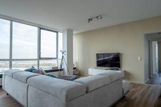 Instapklaar en gemeubeld appartement (125m²) op de 19de verdieping van Residentie 'Panorama Tower'! Op deze hoogte heeft u een uniek zicht op de haven van Antwerpen, de Schelde en het Sint-Annabos. Het appartement is ingedeeld als volgt : inkomhal met ingemaakte vestiairekast; woonkamer (58m²) op parketvloer met open ingerichte keuken op tegelvloer met kasten en toestellen (o.a. gasvuur, microgolf, oven, dampkap, vaatwasser, koelkast, diepvries en ontbijthoek); bergruimte met wasmachine en droogkast (inbegrepen); 2 slaapkamers (22,5m² en 9m²) waarvan de grote slaapkamer een aansluitende dressing heeft; nachthal met apart toilet; badkamer met ligbad, douche en lavabomeubel; terras, kelder en autostaanplaats! Gemeenschappelijke fietsenberging! Zeer rustig gelegen en toch op wandelafstand van winkels en openbaar vervoer! Algemene onkosten bedragen 300 euro / maand (INCLUSIEF provisie CV, privatief waterverbruik, huisvuilophaling, conciërge, lift, poetsen gemene delen)! Beschikbaar vanaf 01 september 2026. EPC: 213 kWh/m²