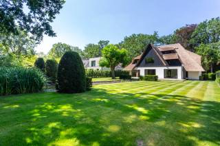 In the sought-after residential area of Vriesdonk in Brasschaat, this exceptional villa with a thatched roof is located, fully renovated according to the refined design by DCX Architecture. Situated on a generous plot of 1,286 m², you will enjoy a unique combination of tranquility, privacy, and excellent accessibility.<br /><br />The house underwent a high-quality energy-efficient total renovation, using only premium materials and modern living comforts. The villa is equipped with underfloor heating and cooling, ensuring a pleasant indoor climate and energy-efficient living all year round.<br /><br />Upon entering the home, you are welcomed by a spacious and bright entrance hall with a cloakroom and a separate guest toilet. From here, you proceed to the large living area, where expansive windows fill the space with natural light and offer a beautiful view of the garden. Adjacent are the dining room and an open kitchen, which can still be customized to your liking. Thanks to the large sliding doors, the indoor and outdoor spaces seamlessly flow into each other, providing direct access to the spacious terrace and the landscaped garden with a large pond—a true oasis where you can enjoy a lovely holiday feeling every day. The ground floor also includes an indoor garage.<br /><br />The first floor features a luxurious master suite with a spacious dressing room and an elegant ensuite bathroom, fitted with a bathtub, a large walk-in shower, double sinks, and storage furniture. Additionally, the property offers four full-sized bedrooms and a second tastefully finished bathroom with a large walk-in shower and double sinks. As an extra asset, there is a large attic floor that offers numerous expansion possibilities.<br /><br />In short, a unique villa where high-quality finishes, energy-efficient comfort, and an exceptional location come together perfectly.<br /><br />Interested? Contact LISTED to schedule a visit: +32 3 283 51 51.