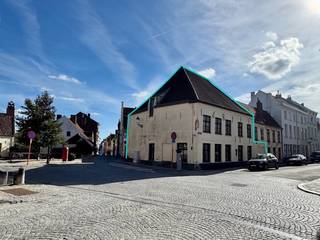 Deze karaktervolle hoekwoning, gelegen in het historische hart van Brugge, in het mooie en gegeerde Sint-Annakwartier, combineert authenticiteit met aangename woonvolumes. Het pand kent een rijke bouwgeschiedenis, met onder meer de jaarankers 1681, en deed in het verleden dienst als apotheek.
De woning beschikt over een inkomhal met toilet, een polyvalente ruimte die kan worden ingericht als leefruimte of werkplek, en een ruime leefruimte met eetplaats en zithoek, met zicht op de tuin. De ruime keuken biedt eveneens toegang tot het terras. Op de verdieping bevinden zich vier slaapkamers en een badkamer. De royale zolder onder de indrukwekkende dakstructuur biedt heel wat mogelijkheden voor verdere inrichting. Vanuit de zolder geniet u bovendien van een mooi zicht op de Jeruzalemkerk.
De aangename tuin vormt een absolute troef in deze historische omgeving.
De woning leent zich zowel tot ruim wonen als tot een combinatie van wonen en werken. De woning heeft EPC-label D en is opgenomen als bouwkundig erfgoed.
Er bestaat eveneens de mogelijkheid om de aanpalende panden aan te kopen, bestaande uit een garage met zolderruimte en een woning met twee slaapkamers en koer. Dit biedt de mogelijkheid om meerdere panden en functies te combineren.
Een uniek pand met karakter, ruimte en bijzonder veel potentieel op een historische locatie.