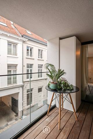 This modern new-build apartment, measuring a spacious 130 m², is located in a prime location in the historic center of Ghent, between Onderbergen and Posteernestraat. Here, you will live amidst the bustling city, with Korenlei, charming restaurants, boutiques, and cultural hotspots within walking distance – yet in a quiet, charming street.<br /><br />The apartment welcomes you with a stylish entrance hall equipped with a cloakroom and guest toilet.<br />The bright open living space offers an ideal layout with a dining area, cozy reading corner, and a fully equipped modern kitchen with an adjoining pantry. Large windows along the entire wall provide an abundance of natural light and a pleasant feeling of space. From the living area, you have access to a spacious indoor terrace – an oasis of peace in the middle of the city.<br /><br />The apartment also features two bedrooms, a shower room, and a luxurious bathroom equipped with a bath, shower, and double sink.<br />In addition to the high-quality finish, the property is technically equipped with underfloor heating and ventilation.<br /><br />An underground parking space is available for €50,000 and must be purchased together with the apartment.<br /><br />This property combines contemporary living comfort with a unique location in one of the most coveted neighborhoods in Ghent – ideal for those who appreciate refinement, tranquility, and urban elegance.<br />Sale under registration fees.