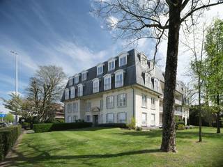 <strong>Ruim appartement of kantoorruimte met karakter, licht en een </strong><strong>uitstekende ligging</strong><br /><br />Op de <strong>gelijkvloerse verdieping</strong> van de standingvolle <strong>residentie 'Versailles'</strong> bevindt zich dit royale <strong>3-slaapkamerappartement (BVO 132 m²)</strong> met <strong>terras</strong>. Ideaal als woonst, praktijk of kantoor.<br /><br />De locatie, vlak bij De Sterre en op slechts tien minuten van het centrum van Gent, maakt dit een bijzonder aantrekkelijke aanbieding voor wie ruimte én bereikbaarheid zoekt.<br /><br />De toon wordt meteen gezet in de <strong>inkomhal</strong>, afgewerkt met <strong>mozaïekparket</strong> en voorzien van een eerste<strong> archief-kamer</strong> en <strong>gastentoilet</strong>. De <strong>leefruimte</strong> strekt zich breed uit en geniet van licht dankzij de <strong>grote raampartijen</strong>, met aansluitend een <strong>terras</strong> dat uitkijkt op het achterliggende groen. De <strong>keuken</strong> kijkt uit op de <strong>gemeenschappelijke tuin</strong> en sluit naadloos aan op de <strong>eetkamer</strong>, praktisch en functioneel.<br /><br />Via de nachthal bereik je <strong>twee ruime kamers</strong> (slaapkamers of kantoorruimtes), <strong>gescheiden door een centrale badkamer</strong> met wastafel, toilet en ligbad. Verder zijn er een aparte wasplaats en een extra gastentoilet aanwezig.<br /><br />De residentie ademt grandeur, is uitstekend onderhouden en biedt bewoners bovendien een privatieve kelderberging en toegang tot het groene, gemeenschappelijke domein dat de drukte van de Kortrijksesteenweg volledig verzacht.<br /><br />Station Gent-Sint-Pieters, UZ Gent, Maria Middelares, de N43, N60, E17 en E40 liggen binnen handbereik: <strong>een ideale combinatie voor wie mobiliteit belangrijk vindt.</strong><br /><br /><strong>Een unieke kans voor wie gevoelig is aan authenticiteit en op zoek is naar een royale woon- of werkplek op een bijzonder gunstige locatie.</strong><br /> 