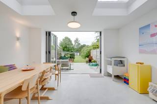 <p><strong>Op de grens van Wilrijk en Edegem woon je hier op een plek waar stad en groen opvallend mooi samenvallen. Rustig gelegen, met wandelmogelijkheden in de buurt en tegelijk vlakbij Antwerpen en invalswegen. Maar wat dit huis écht bijzonder maakt, voel je pas wanneer je er bent. Want zelden krijg je langs beide kanten zo’n open groen zicht cadeau. Vooraan kijk je uit op weides, achteraan strekt een diepe tuin zich uit. En daartussen? Een woning die baadt in het licht, doordacht werd vernieuwd en waar architectuur en dagelijks leven vanzelfsprekend samenkomen. Kom binnen…</strong></p><p></p><p><strong>Een huis dat meteen anders aanvoelt<br /></strong>De inkomhal brengt je naar de kelder, de trap en de leefruimte, maar eigenlijk begint het verhaal al vroeger. Dit is zo’n woning waar de rust onmiddellijk over je heen daalt. Niet koel of afstandelijk, wel warm en uitnodigend.</p><p></p><p><strong>Waar het leven samenkomt</strong><br />De huidige eigenaars kochten de woning in 2021 en vernieuwden in 2022-2023 de leefruimte en badkamer. Het resultaat voelt opvallend coherent aan, met als blikvanger de ingerichte benedenruimte van Studio Toto. En die doet precies wat sterke architectuur hoort te doen: licht, ruimte en leven samenbrengen. De open keuken is het kloppende hart van het huis, met een eiland, terrazzo werkblad en AEG-toestellen. Veel bergruimte, veel werkplek en vooral: veel connectie met de rest van de woning.</p><p></p><p>Maar het is het licht dat hier alles draagt. Dakkoepels trekken het daglicht diep naar binnen en het aluminium harmonicaraam opent volledig naar het terras. Daardoor voelt de leefruimte niet afgesloten van buiten, maar er haast in verweven.</p><p>De polybetonvloer met vloerverwarming in keuken en eetruimte geeft een rustige, strakke basis, terwijl de parketvloer in de zithoek warmte toevoegt. Ingebouwde diepe kasten en een zitbank met opbergruimte maken het geheel slim én sereen.</p><p></p><p><strong>Groen aan twee kanten<br /></strong>Het terras in polybeton sluit naadloos aan op de diepe tuin van 240 m², met tuinhuis, vernieuwde achtergevel, verlichting, kraan en stopcontacten. Ook onder het terras werd al vooruitgedacht met een wachtbuis. Maar misschien ligt de grootste luxe hier gewoon in het uitzicht. Achteraan opent het groen zich breed, terwijl je vooraan uitkijkt op de weides van diergeneeskunde met dartelende paarden. Dat dubbele groene decor maakt deze woning uitzonderlijk: beschut en rustig, maar tegelijk op een steenworp van de stad.</p><p></p><p><strong>Slapen in alle rust<br /></strong>Op de eerste verdieping ligt een slaapkamer met ingemaakte kasten en zicht op de tuin. Ook de badkamer werd vernieuwd en kreeg XL terrazzo tegels, een bad, douche en dubbele lavabo. De nis voor wasmachine en droogkast werd slim geïntegreerd, net als het aparte ruime toilet met lavabo.</p><p></p><p><strong>Nog een laag vol mogelijkheden<br /></strong>De tweede verdieping telt nog twee slaapkamers. Eén daarvan verrast met hoge plafonds en een mezzanine die vandaag dienst doet als kleine zolder. De andere stoeft met ingebouwde kasten.</p><p></p><p><strong>Fris, lichtrijk en helemaal af<br /></strong>Met een EPC B, vloerverwarming beneden, rolluiken en een sterke renovatie staat hier vandaag een woning die klopt. Met het prachtig binnenvallende licht, het groene zicht langs twee kanten en een leefruimte die architectuur en comfort mooi laat samenvallen, weet je het meteen: dit is de plek waar jij binnenkort je hart verliest.</p><p></p><p><strong>Verliefd? Info@ugly.be</strong></p>