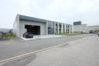 Samenvatting:
<ul>
	<li>Perceel van ± 20 are</li>
	<li>Bedrijfshal ± 700 m² met ±6 meter vrije hoogte</li>
	<li>Atelier/opslagruimte ± 60 m² (hoogte ca. 3m10)</li>
	<li>Uitgeruste keuken </li>
	<li>Bureelruimte ± 100 m², vrij in te richten</li>
</ul>
Op een goede locatie te Alfajetlaan 2211 in Sint-Truiden biedt deze bedrijfsruimte op een perceel van net geen 20 are tal van mogelijkheden voor ondernemers die ruimte, bereikbaarheid en flexibiliteit zoeken.<br /><br />De hal zelf beslaat ongeveer 700 m² en is dankzij de vrije hoogte van 6 meter perfect geschikt voor uiteenlopende bedrijfsactiviteiten zoals productie, opslag of logistiek. Aanpalend vinden we een extra ruimte van circa 60 m² die dienst kan doen als atelier of bijkomende opslagplaats, met een hoogte van ongeveer 3m10. Verder is er een volledig uitgeruste keuken die kan dienst doen als vergaderruimte of refter. De bovengelegen bureelruimte van ongeveer 100 m² biedt nog de vrijheid om in te richten volgens uw eigen noden, van kantoor tot showroom.<br /><br />Dankzij de indeling en de oppervlakte is dit een interessante uitvalsbasis voor zowel kmo’s als bedrijven die op zoek zijn naar uitbreiding of centralisatie van hun activiteiten.<br /><br />Interesse? Neem contact op met Aktimmo voor een bezoek en een verkenning van de mogelijkheden.