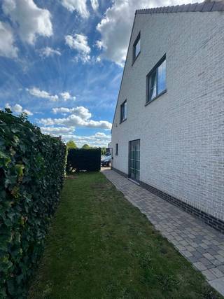 Instapklare woning met 3 slaapkamers, garage en tuin
Deze instapklare halfopen bebouwing is als volgt ingedeeld:
Op het gelijkvloers: via de ruime inkomhal, voorzien van een gastentoilet, komt u in de aangename leefruimte. Deze bestaat uit een ruime zithoek en eetplaats en geniet dankzij de grote raampartijen en dubbele schuifdeur van een mooie lichtinval en een rechtstreeks zicht op de tuin. De reeds aanwezige schouw biedt bovendien de mogelijkheid om een haard te plaatsen.
De aangrenzende keuken is uitgerust met een kookplaat, dampkap, oven en koelkast en beschikt over voldoende kastruimte. Vanuit de keuken is er rechtstreeks toegang tot het terras en de tuin.
Verder beschikt het gelijkvloers over een ruime wasplaats/berging en een praktische garage.
Via de trap in de inkomhal kom je op de eerste verdieping. Hier bevinden zich drie ruime slaapkamers en een aparte bureauruimte, ideaal als thuiswerkplek of hobbyruimte.
De bijzonder ruime badkamer is uitgerust met een douche, ligbad en dubbel lavabomeubel.
De woning beschikt bovendien over een zeer ruime zolder, bereikbaar via een uittrekbare trap. De zolder is reeds voorzien van een afgewerkt raam en een vloer van geperst hout, waardoor deze ruimte mits verdere inrichting mogelijkheden biedt voor één of meerdere extra slaapkamers, een hobbyruimte of polyvalente ruimte.
De oprit biedt plaats voor 3 wagens.
De woning geniet een uiterst gunstige en vlot bereikbare ligging. Op wandelafstand bevinden zich diverse bushaltes. Ook belangrijke invalswegen en fietspaden zijn vlot bereikbaar, waardoor zowel het centrum als omliggende gemeenten gemakkelijk bereikbaar zijn.