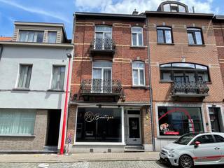 Deze woning is gelegen op een toplocatie in het centrum, dichtbij vele faciliteiten, winkels, scholen, openbaar vervoer en is uitstekend bereikbaar . De woning is ingedeeld in een commercieel gelijkvloers van 68 m² en 2 wooneenheden. Het appartement op de 1e verdieping heeft een oppervlakte van 55m² en omvat: salon, eetkamer, balkon vooraan, ingerichte keuken (gasfornuis, dampkap), 1 slaapkamer en badkamer (douche, lavabo en wc). Op de 2e verdieping is er een duplex appartement van 55 m², deze omvat: een ruime woonkamer, ingerichte keuken (oven, gasfornuis, dampkap,. Via een trap in de woonkamer gaat u naar de zolderverdieping waar er zich een slaapkamer bevindt met een badkamer (bad, lavabo en wc). De woning beschikt ook over kelders. Er is overal dubbele beglazing in PVC voorzien. De woning wordt verwarmd op gasconvectoren. Er zijn aparte meters voor de elektriciteit en de gas.