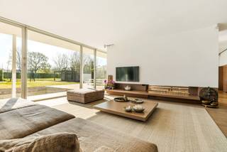 Schitterende moderne villa (bouwjaar 2001) met kantoren/praktijk of extra leefruimte op prachtige kavel van 3.140 m² is gelegen nabij het centrum van Dessel. Deze villa is afgewerkt met hoogwaardige materialen, geniet van enorm veel lichtinval en heeft bovendien een prima EPC-score van 137 kWh/m²/jaar (B-label). Het eigendom omvat zeer mooie open leefruimtes met exclusieve keuken, een complete wellness, wijnkelder, 3 slaapkamers, 2 badkamers, een grote garage, een aparte vleugel die momenteel dienst doet als praktijk, maar perfect kan omgevormd worden tot bv gastenverblijf, kantoren of extra leefruimte,... zeer mooie tuin met buitenzwembad en poolhouse. <br /><br />Gelijkvloers: <br />Via een stijlvolle inkomhal met vestiaire en gastentoilet bereikt u de villa. De grote pivot deuren brengen u naar de imposante woonkamer met hoge plafonds (3m) en een gezellige doorkijkhaard tussen de eetkamer en de zithoek. De moderne leefkeuken met minimalistisch design en natuurstenen werkblad is voorzien van alle comfort met oa een AGA kookfornuis voorzien van 4 ovens. De keuken staat in rechtstreeks contact met de overige leefruimte. Zo treft u hier nog een sfeervolle zithoek met aanpalend kantoor op parket, dewelke volledig kan worden afgesloten van de woonkamer. De grote raampartijen aan de volledige achterzijde van deze villa zorgen voor enorm veel daglicht. U geniet van een rechtstreekse toegang van de leefruimtes naar het overdekte terras aan de achterzijde. Van hieruit kunt u heerlijk genieten met zicht op uw schitterend aangelegde tuin. <br />De zij-inkom biedt toegang tot het praktisch gedeelte van de villa. Hier treft u een volledig ingebouwde kastenwand, een badkamer met ruime inloopdouche en toilet. Via de hal bereikt u de dubbele garage met elektrische poort.<br />Het praktijkgedeelte beschikt over een separate inkomhal met een wachtkamer en onthaalruimte. Hier bevinden zich 3 volledig uitgeruste behandelkamers/kantoren en een royale fitnessruimte/polyvalente ruimte. <br /><br />Eerste verdieping:<br />Via de trappenhal bereikt u de eerste verdieping met 3 slaapkamers, waaronder 2 kinderkamers en een ruime masterbedroom met aangrenzende dressing. De verdieping is volledig voorzien van massieve parketvloeren. De badkamer is uitgerust met Travertin en Carrara<br />marmer, een Philippe Starck-ligbad en Vola-kranen. De inloopdouche werd recent nog gerenoveerd.<br /><br />Kelderverdieping/Wellness:<br />De volledig onderkelderde verdieping is ingericht als een exclusieve privé-wellness. U vindt hier oa een jacuzzi, een hammam, een luxe sauna met dompelbad, een keienbad, wisselbaden en verwarmde ligbanken met kleurentherapie. Loungeruimte met houthaard aanwezig om gezellig te ontspannen. Er zijn ook 2 buitendouches aanwezig. De gehele<br />kelderverdieping, inclusief de wasplaats, is afgewerkt met een granieten natuurstenen vloer. Er werd geopteerd voor kraanwerk van het exclusieve merk Dornbracht. Naast de wellness bevinden zicht 3 extra kamers die multifunctioneel gebruikt kunnen worden, alsook een aparteruimte met infraroodcabine en douche. De wellness kreeg een nominatie voor de “Mooiste Privésauna van Vlaanderen” door Knack-Wellness.<br /><br />Tuin:<br />Het perceel is volledig omheind en aangelegd met een royaal terras en een verwarmd zwembad met poolhouse, dat is uitgerust met toilet en douche. De gevelbekleding van Massangis kalkzandsteen. De zuidoostelijke oriëntatie zorgt voor optimaal zonlicht, en de voortuin biedt parkeerruimte voor 7 - 10 auto’s, exclusief de garage. <br /><br />Bijzonderheden:<br />- Ideale woning voor de thuiswerker, een gezin of koppel dat wil genieten van alle luxe comfort.<br />- Strakke afwerking/interieur: weggewerkte plinten, ingebouwde verlichting, maatwerk kasten... <br />- Conforme elektriciteitskeuring<br />- Zwembad wordt dmv warmtepomp<br />- Zonnepanelen - ca. 11.000 kwh/m²<br />- Asbestveilig<br />- EPC label B<br />- Grondwaterput van 203m diepte