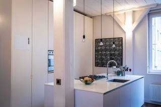 We verkopen de plek waar we zelf meteen verliefd op werden: een licht en bijzonder rustig appartement met loftgevoel van 100 m², verscholen in een uniek houten pakhuis in het hart van Antwerpen. Eens binnen hoor je niets meer van de stad, alleen de rust en het groen rond het gebouw.<br /><br />Het appartement werd volledig gerenoveerd in 2015 en kreeg in 2022 een prachtige glazen wand in Oregon pine. De afwerking in eik en Japanse rode den geeft de ruimte een warme, natuurlijke uitstraling. De leefruimte voelt royaal aan, en dankzij de plafondhoge ramen in de twee slaapkamers blijft het loftgevoel volledig behouden. Door de kastenwand in de open keuken kom je bij een bijzonder handige berging/wasruimte<br /><br />Op het terras van 6 m² kan je in de ochtendzon ontbijten en kijk je uit op groene binnentuinen, een kleine dagelijkse luxe.<br /><br />Praktisch zit alles perfect: EPC B, elektriciteit conform (recent), geen asbest, gloednieuwe condensatieketel (2024), vernieuwd gemeenschappelijk puntdak (2025) en een ruime kruipruimte onder het hele appartement die dienstdoet als extra berging. Via de garage kom je in een overdekte binnenpatio met plek voor fietsen, bakfietsen en buggy’s. Oh ja, en een mobiscore van 9,5 op 10. <br /><br />Het is een plek waar we met veel plezier woonden, en die we met evenveel liefde doorgeven aan iemand die hier net zo graag wil thuiskomen.<br /><br />