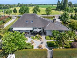 Deze charmante villa is uitstekend gelegen op een vlot bereikbare locatie, op korte afstand van het centrum van Oostmalle. Hier geniet u van een ideale combinatie van rust, ruimte en bereikbaarheid. Bovendien bestaat de mogelijkheid om de achtergelegen weilanden bijkomend aan te kopen.<br /><br />INDELING:<br /><br />Via de mooie oprit bereikt u de woning. Bij het binnenkomen wordt u verwelkomd in een ruime inkomhal. Rechts bevindt zich de lichtrijke leefruimte, die dankzij de vele raampartijen geniet van een aangename lichtinval en een prachtig uitzicht biedt op de fraai aangelegde tuin. Aansluitend bevindt zich de volledig uitgeruste keuken, die rechtstreeks toegang verleent tot het gezellige terras.<br /><br />Links van de inkomhal bevindt zich het slaapgedeelte. De woning beschikt over drie ruime slaapkamers en twee comfortabele badkamers. De eerste badkamer is uitgerust met een enkele lavabo, een ligbad en een toilet. De tweede badkamer beschikt over een dubbele lavabo en een inloopdouche. Via deze badkamer bereikt u bovendien een praktische bureauruimte, een wasplaats en een extra toilet.<br /><br />Verder beschikt de woning over een ruime bergzolder, wat zorgt voor extra opslagmogelijkheden.<br /><br />Buiten geniet u van een prachtig aangelegde, volledig omheinde tuin waar u in alle rust kunt ontspannen. Achter de afsluiting bevindt zich nog een extra perceelsgedeelte met een garage, een opslagplaats en een ruim magazijn. Deze bijkomende gebouwen bieden tal van mogelijkheden voor hobbyisten, zelfstandigen of wie op zoek is naar extra bergruimte.<br /><br />Kortom, een ruime en veelzijdige woning met een uitstekende ligging, ideaal voor gezinnen of wie wonen en werken wenst te combineren.<br /><br />BIJZONDERHEDEN: <br />- Goede bereikbare locatie<br />- Veel mogelijkheden <br />- Veel ruimte<br />- Aangelegde tuin<br /><br />Voor meer info of een bezoek ter plaatse kan u vrijblijvend contact opnemen met Lieselotte op 03.227.58.58 of lieselotte@reds.be.