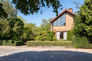 <p><strong>Op een mooi perceel van ca. 1.350 m², zuidwest georiënteerd en met een prachtig uitzicht over de achterliggende velden, bevindt zich deze bijzonder degelijke villa op een fijne ligging tussen Turnhout en Baarle-Hertog met 3/4 slaapkamers, prachtige zolderverdieping en een energielabel C.<br /><br /></strong>Deze woning ademt het karakter van de jaren 70 en onderscheidt zich door haar authentieke architecturale details, eiken vloeren, typische metselwerkelementen en een bijzonder ruime indeling destijds ontworpen door de eigenaar. Met 3 à 4 slaapkamers, een volledige kelderverdieping die toegankelijk is met de wagen en een royale polyvalente bovenverdieping biedt deze woning bovendien tal van mogelijkheden.</p>
<p>Via de inkom bereikt u de gezellige leefruimte. De ruime woonkamer beschikt over een aangename zithoek op parket bij de haard en biedt uitzicht op de voortuin en de straat. De eetkamer vormt het centrale hart van de leefruimte en sluit mooi aan op zowel het salon als de keuken. De keuken kijkt uit over de tuin en is uitgerust met een ruim werkblad, ontbijthoek en de nodige toestellen. Aan de eettafel is het heerlijk vertoeven met het gezin of met gasten, terwijl het zicht op de groene omgeving voor een aangename sfeer zorgt.<br /><br /><span>Vanuit de woonkamer bereikt u de nachthal met drie volwaardige slaapkamers waarvan de twee ruimste kamers ingericht zijn met maatwerk kasten. Bijzonder veel daglicht op deze slaapkamers waardoor het aangenaam vertoeven is door het zicht op de achtertuin. De badkamer is ingericht met een ligbad, maatwerkkast, toilet en een wastafel. De doucheruimte is apart. Er is nog een extra toilet aanwezig in de nachthal.</span></p>
<p>Een bijzondere troef van deze villa bevindt zich op de bovenverdieping. Deze royale polyvalente ruimte van ca. 120m² geniet van indrukwekkende vergezichten over de omgeving en biedt uitzicht in alle windrichtingen. Ze kan naar eigen behoefte worden ingericht als hobbyruimte, bureau, atelier of worden opgedeeld in bijkomende slaapkamers. Er is makkelijk een extra badkamer te creëren gezien aan en afvoer voor water al voorzien zijn.</p>
<p>Ook de kelderverdieping is een absolute meerwaarde. Dankzij haar uitzonderlijke oppervlakte vindt u hier onder meer een logeerkamer, een grote hobby- of ontspanningsruimte en meer dan voldoende plaats voor één of meerdere wagens, fietsen en bijkomende berging. De kelder is rechtstreeks toegankelijk met de auto.</p>
<p>De combinatie van de solide bouwkwaliteit, het uitgesproken karakter, de royale volumes en de prachtige ligging met zicht over de velden maakt van deze villa een eigendom met bijzonder veel potentieel. Prachtige toegankelijk tuin met oprit tot ondergrondse garage, een tuinserre en siertuin met gazon en boomgaard met verschillende fruitbomen.</p>
<p>Bijzonderheden:</p>
<ul>
<li>Prachtig perceel, destijds 2 bouwpercelen uitkijkend over weiland</li>
<li>Kleuter en lagere school op fietsafstand</li>
<li>Boververdieping volledig naar wens in te richten</li>
<li>Energielabel C.</li>
</ul>