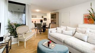 <p>Cet appartement d’environ 63 m² est situé au premier étage de la petite résidence neuve Hof van Leysen, un projet d’angle architectural raffiné conçu par M2 Architecten. La résidence doit son nom à son emplacement unique, à proximité du parc éponyme, qui traverse ce quartier résidentiel élégant comme une artère verte et offre une sensation exceptionnelle de calme et d’espace.</p>
<p>L’appartement se trouve dans la très recherchée Markgravelei, en plein cœur du quartier Markgrave. L’emplacement est particulièrement pratique : à deux pas de la Jan Van Rijswijcklaan, avec un accès direct au Ring et au Singel, et à distance de marche du centre-ville. À proximité immédiate, vous trouverez de nombreux cafés et restaurants conviviaux tels que Domestic, Bunch, The Finch, Cèpes et Café Kamiel, bientôt rejoints par Cobra House.</p>
<p>Conçu par M2 Architecten, l’appartement bénéficie de finitions haut de gamme. Le séjour avec cuisine ouverte dispose d’un parquet continu et donne un accès direct à la terrasse orientée sud-est, d’où vous pourrez profiter en toute tranquillité de la vue sur le parc Hof van Leysen.</p>
<p>La cuisine moderne, blanche et sans poignées, est entièrement équipée avec des appareils encastrés de qualité, comprenant une plaque de cuisson, un lave-vaisselle, un réfrigérateur avec compartiment congélateur et un four combiné. La chambre dispose de placards encastrés et est attenante à la salle de bain, aménagée avec une douche, un lavabo et des toilettes.</p>
<p>De plus, un espace de rangement séparé avec branchement pour machine à laver est prévu. L’appartement est prêt à emménager et extrêmement économe en énergie, avec notamment un chauffage au sol continu. Une cave privative est incluse dans le prix et un local à vélos commun est disponible.</p>