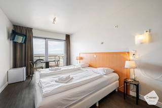 Deze studio met <strong>prachtig</strong> <strong>zeezicht</strong> ligt op een <strong>goede</strong> <strong>locatie</strong>, dicht bij het centrum.<br /><br />Bij het binnenkom van de studio situeert zich aan de linkerzijde een stapelbed. Daar recht tegenover bevindt er zich een <strong>vernieuwde</strong> <strong>badkamer</strong> met een ruime douche, mooie tegels, een toilet en een wasbak met spiegel.<br /><br />Een stapje verder (dit mag je letterlijk nemen), kom je in de <strong>leefruimte</strong> met een groot bed. De studio heeft ook een <strong>terras</strong> die een <strong>prachtig</strong> <strong>zicht</strong> heeft over de zee.<br /><br />De studio wordt verkocht onder de formule van <strong>erfpacht</strong>. Dit biedt verschillende voordelen, zoals een <strong>lagere</strong> <strong>aankoopprijs</strong> gezien de grond niet aangekocht wordt. Voor het gebruik van de grond betaalt de erfpachter aan de grondeigenaar een jaarlijkse som geld, ook wel canon genoemd. Deze canon is <strong>fiscaal</strong> <strong>aftrekbaar</strong>.<br /><br />Momenteel wordt deze studio <strong>verhuurd</strong> via een <strong>hotelpoule</strong> die de suite verhuurt op vakantiebasis, waarop de eigenaar een percentage van de winsten verkrijgt. Het is ook mogelijk om zelf de suite te reserveren voor eigen gebruik.<br /><br />Het is <strong>niet</strong> mogelijk zich hier te <strong>domiciliëren</strong>, de studio kan enkel gebruikt worden als vakantieverblijf.