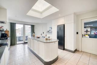 Op een boogscheut van het centrum, wandelwegen en het openbaar vervoer bevindt zich deze ruime en instapklare woning. Dankzij de vele natuurlijke lichtinval geniet de woning van een aangename en warme sfeer. De open keuken vormt samen met de leefruimte een gezellige plek en biedt bovendien een mooi zicht op de tuin.<br /><br />De woning beschikt over drie ruime slaapkamers en een verzorgde badkamer met zowel een ligbad als een douche. Daarnaast is er heel wat bergruimte aanwezig, wat zorgt voor extra praktisch comfort.<br /><br />Een absolute troef is de ruime garage, die niet alleen geschikt is voor het stallen van fietsen, brommers en moto's, maar ook voldoende plaats biedt voor gereedschap en allerhande materiaal.<br /><br />Ook op technisch vlak werd de woning goed onderhouden en vernieuwd. Zo werd het dak vernieuwd, zijn er zonnepanelen aanwezig en werd de condensatieketel vernieuwd. Daarnaast zorgt een warmtepomp voor het warme water.<br /><br />Buiten kunt u genieten van een grote, verzorgde tuin en een aangenaam terras, ideaal om tot rust te komen of gezellig samen te genieten van mooie dagen.<br /><br />Deze woning combineert ruimte, comfort en praktische voorzieningen met een uitstekende ligging nabij het centrum, wandelwegen en openbaar vervoer. Een ideale thuis voor wie op zoek is naar een verzorgde woning waar u zonder grote werken meteen kunt intrekken.