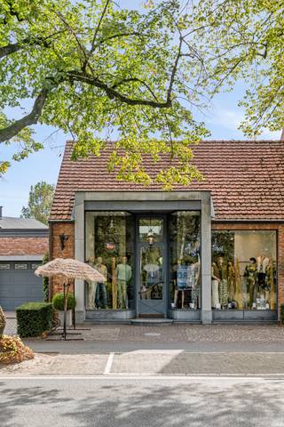 Karaktervolle handelswoning dat enerzijds bestaat uit een gerenoveerd handelsgedeelte met garage en apart toilet en kitchenette dat momenteel wordt ingevuld als kledingzaak maar ook de mogelijkheid biedt dit te gebruiken als kantoorruimte/vrij beroep/etc. Aansluitend bevindt zich het woongedeelte dat dateert uit de '30 en waarbij de authentieke elementen behouden zijn gebleven. De woning bestaat uit keuken, leefruimte, gelijkvloerse badkamer, apart toilet, 3 slaapkamers, zolder en kelder.<br /><br />Indeling:<br />Handelsgedeelte:<br />De handelszaak is volledig gerenoveerd en uitgebreid in 2001 waarbij gebruik is gemaakt van grote glaspartijen en behoud van de authentieke balken. Dit gedeelte kan multifunctioneel worden ingevuld en is voorzien van een apart toilet en kitchenette en toegang tot de inpandige garage met automatische poort. <br /><br />Woning gelijkvloers:<br />De woning is zowel via een aparte voordeur als via de handelszaak bereikbaar. Deze bestaat uit een zeer charmante inkomhal met hoge plafonds, houten trap, moulures, etc. De keuken is apart voorzien en geeft via een dubbele deur toegang tot de charmante woonkamer met open haard en glas in lood ramen. op de gelijkvloerse verdieping bevindt zich ook de badkamer met dubbele lavabo en ligbad, apart toilet, technische ruimte en toegang tot de kelder.<br /><br />Woning eerste verdieping:<br />De eerste verdieping is voorzien van 3 ruime slaapkamers en aparte dressing dat eventueel nog als bijkomende kinderkamer of bureauruimte gebruikt kan worden. De zolder is toegankelijk via een vlizotrap.<br /><br />Tuin:<br />De tuin is fraai aangeplant en voorzien van een overdekt bijgebouw/terras. Deze is zuidoost georiënteerd waardoor het hier zalig genieten is van de zon en volledig omheind.<br /><br />Bijzonderheden:<br />- handelswoning met vele mogelijkheden op centrale locatie<br />- zoldervloer geïsoleerd<br />- Behoud van authentieke elementen<br />- Winkel wordt momenteel uitgebaat door eigenares. Beschikbaarheid of tijdelijke verdere uitbating na verkoop is bespreekbaar.<br />- privé staanplaatsen voor het pand