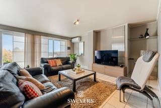 Interesse? Meer informatie op www.SWEVERS.be. - Dit instapklare appartement op de derde verdieping aan de Grote Baan in Houthalen-Helchteren biedt 116 m² wooncomfort op een zeer centrale locatie. De ruime en lichtrijke leefruimte van 35 m² met airco sluit aan op een praktische, gerenoveerde open keuken. Het appartement beschikt over drie volwaardige slaapkamers, een vernieuwde badkamer en is onmiddellijk bewoonbaar.<br /><br />Extra troeven zijn de twee terrassen (10 m² vooraan en 3 m² achteraan), elektrische rolluiken, vliegenramen, lift, een vrijstaande garage en een kelderberging. Dankzij privé zonnepanelen (2022) en een gunstig EPC is het appartement energiezuinig.<br /><br />Met scholen, openbaar vervoer, winkels en ontspanning op wandelafstand en een vlotte verbinding naar de snelweg, combineert deze woonst ruimte, comfort en een uiterst praktische ligging. Bel ons vandaag nog voor een persoonlijke rondleiding. Wij van Swevers Real Estate helpen je maar al te graag verder. tel. 011 255 155. Bron bewoonbare oppervlakte: EPC-verslag.