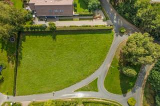 Het perceel is prachtig omzoomd door volwassen bomen en hagen, wat zorgt voor een natuurlijke buffer en absolute gemoedsrust. Dankzij de gunstige oriëntatie baadt uw toekomstige woning de hele dag in het natuurlijke licht. Bovendien grenst de grond aan agrarisch landschap, wat het weidse, landelijke karakter van uw tuin alleen maar versterkt.<br /><br />Veilig, sereen én uitstekend verbonden<br />Wonen in het Vlieringenpark betekent wonen in een veilig, residentieel privédomein, toegankelijk via een automatische toegangspoort. Hoewel u hier volop geniet van de rustige natuur, hoeft u niet in te boeten op bereikbaarheid. U bevindt zich op amper tien kilometer van Brussel, met een bijzonder vlotte verbinding richting de hoofdstad. Ook lokaal is de ligging ideaal.<br /><br />Een onbebouwd perceel in dit gegeerde domein is een ware zeldzaamheid. Met zijn indrukwekkende oppervlakte, veilige setting en de perfecte balans tussen een groene omgeving en een vlotte bereikbaarheid, biedt deze grond u het ideale blanco canvas om de woning van uw dromen te realiseren.<br /><br />Bestuursmaatregelen in het maatregelenregister: nee