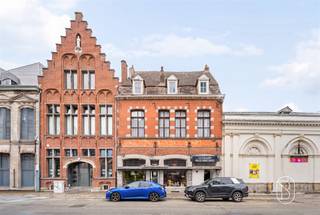 <p>Voormalig poststation uit de 18e eeuw, momenteel ingericht als winkelpand met woonruimte, ideaal gelegen vlak bij het station, de bushaltes, het stadscentrum en de hoofdwegen.</p><p>Het pand heeft een bebouwde oppervlakte van 537 m² en bestaat op de begane grond uit een entreeportaal dat tevens dienst doet als garage, een winkelruimte van 62 m² met een grote etalage aan de straatkant, een woonkamer, een keukenruimte, een toilet, een terras van +/- 60 m² en een werkplaats achteraan op het perceel, de voormalige stallen.</p><p>Op de verdiepingen: woonkamer, eetkamer, oude keuken, twee badkamers, drie slaapkamers, een inrichtbare ruimte en zolders/dakruimtes met veel potentieel.</p><p>Kenmerken: centrale verwarming op stookolie, boiler voor warm water, houten kozijnen met enkel glas, kadastrale oppervlakte van 3 are 27 centiare. Er zijn ingrijpende renovatiewerkzaamheden nodig.</p><p>Prijs vanaf 250.000 €</p><p>EPB: klasse E</p>