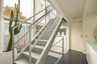 <p><strong>ARCHITECTENWONING MET MULTIFUNCTIONELE RUIMTE TE KOOP – VELTWIJCKPARK EKEREN</strong><br />Zoekt u een unieke woning waar u wonen en werken perfect kunt combineren, met extra ruimte voor uw gezin, een atelier of hobby? Wilt u centraal wonen met de natuur binnen handbereik en heeft u een hart voor moderne architectuur? Dan is deze eigendom precies wat u zoekt.</p>
<p><strong>LOCATIE & OMGEVING </strong><br /><strong>Immo Point VANDAELE</strong> stelt met trots deze architecturale parel voor. U woont hier uiterst centraal, op 450 m van het levendige centrum, 700 m van de Antwerp International School en diverse scholen binnen 1 km. Het treinstation ligt op 850 m met rechtstreekse verbindingen naar Antwerpen en Brussel, en via nabijgelegen fietsostrades staat u op 8,6 km op de Grote Markt van Antwerpen.</p>
<p>Daarnaast woont u in een groene oase: steek simpelweg de straat over voor een wandeling of hardloopsessie rond Kasteel Hof van Veltwijck, in het Veltwijckpark en in natuurgebied De Oude Landen.</p>
<p><strong>ARCHITECTUUR & TECHNIEK </strong><br />Gebouwd naar een sprekend ontwerp van architect Lou Jansen. De doordachte architectuur combineert functionaliteit met een overvloed aan natuurlijk licht.</p>
<p><strong>INDELING VAN DE WONING </strong><br /><strong>Gelijkvloers </strong><br />(Wonen & werken, atelier of hobby) Een multifunctionele ruimte van ca. 70 m² met afzonderlijke inkom en badkamer, ideaal voor een vrij beroep, praktijk of atelier. Daarnaast is er een apart bureel met rustgevend zicht op de tuin.</p>
<p><strong>Eerste verdieping </strong><br />De inkomhal is toegankelijk via een karakteristieke buitentrap. De royale, lichtrijke leefruimte (ca. 60 m²) beschikt over een gashaard en een speel- of leeshoek. De grote leefkeuken (ca. 25 m²) biedt directe toegang tot het terras. Verder vindt u hier een praktische waskamer en toilet.</p>
<p><strong>Tweede verdieping </strong><br />De nachthal heeft een apart nachttoilet en geeft toegang tot 3 volwaardige slaapkamers (elk ca. 14 m²) en een comfortabele, ruime badkamer.</p>
<p><strong>Ondergronds</strong> <br />Er is een ruime kelder én een aparte archiefruimte.</p>
<p><strong>PERCEEL & TUIN </strong><br />De ligging op een hoekperceel zorgt voor een maximaal gevoel van licht en ruimte. De volwassen, prachtig aangelegde tuin met idyllische vijverpartij creëert een heerlijk 'cocoon-effect'.</p>
<p><strong>KORTOM</strong> <br />Een lichtrijke architectenwoning met een zee aan ruimte op een toplocatie tegenover het Veltwijckpark, vlak bij alle voorzieningen en met een tuin om volledig tot rust te komen.</p>
<p><strong>BEWOONBARE OPPERVLAKTE</strong><br />De vermelde bewoonbare oppervlakte is gebaseerd op de bruikbare vloeroppervlakte uit het EPC.</p>