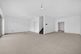 <p><span>U parkeert op de ruime autostaanplaats van deze nieuwbouwwoning (verkoop onder btw-stelsel, 21% btw van toepassing) en hebt vervolgens de keuze tussen de voordeur en een praktische zij-ingang via de wasplaats (aanpalende berging). Ondertussen is uw oog gevallen op de lange betonnen gevelsteen (gelijmd), het witte sierpleisterwerk en de kabel voor uw toekomstige laadpaal. Alles aan deze BEN-woning is royaal bemeten: van de ruime hal en nachthal tot het bureel (met UTP-aansluiting), de kamers en de toiletten, inclusief de L-vormige living met hoog plafond die aansluit op de open keuken met eiland. In de keuken wordt gewerkt met kwaliteitsapparaten en het contrast tussen hout en witte oppervlakken. De circa 7m brede raampartij kijkt uit op een 8m breed terras en een diepe, omheinde tuin (grasveld). Degelijkheid van materialen staat voorop: donkerbeige alu-ramen, trappen bekleed met zwart composiet, grote grijze tegels, algemene vloerverwarming, warmtepomp, 12 zonnepanelen en volledig afgewerkte geprofileerde binnendeuren met 3 stevige scharnieren. De badkamer op de eerste verdieping omvat een acrylbad, een groot dubbel lavabomeubel en een inloopdouche. De kamers met grote ramen zijn voorzien van laminaat. Onder dak staan nog eens 2 flink uit de kluiten gewassen kamers ter beschikking, die beschikken over een eigen badkamer, incl. inloopdouche (glazen wand), hangtoilet en dubbel meubel. U woont hier in een rustige straat, op wandelafstand van het dorpscentrum.</span></p><p><span> </span></p>