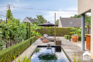 <p>Ontdek deze prachtige lichtrijke villa, gebouwd in 2007, waar ruimte, comfort en moderne technologie hand in hand gaan. Dankzij de gunstige ligging geniet u van rust en een vrij uitzicht op groen, terwijl winkels, scholen en belangrijke invalswegen toch vlakbij liggen.</p>
<p>De leefruimte met gezellige open haard en vloerverwarming vormt het hart van het huis en sluit naadloos aan bij de volledig ingerichte keuken. Alle verlichting is stijlvol ingebouwd.</p>
<p>Deze woning is volledig instapklaar en werd uitgerust met tal van hedendaagse voorzieningen met o.a. domoticasysteem, airconditioning en warmtepomp, 30 zonnepanelen en screens voor alle ramen. </p>
<p><strong>Troeven:</strong></p>
<ul><li>Gunstig EPC B-label (121 kWh/m²)</li><li>Elektriciteit is conform</li><li>Domoticasysteem, persoonlijk instelbaar en vanop afstand bedienbaar</li><li>Airconditioning en warmtepomp (30 zonnepanelen)</li><li>Volledige kelderverdieping</li><li>Inpandige garage voor 2 auto’s</li><li>Mogelijkheid tot 4/5 slaapkamers</li><li>2 badkamers</li><li>Noordgerichte tuin + zuidgerichte tuin met zwemvijver</li></ul>
<p><strong>Indeling:</strong></p>
<ul><li>Gelijkvloers: Inkomhal; toilet; leefruimte + zithoek (112 m²); keuken (23 m²); berging; inpandige garage voor 2 auto’s.</li><li>Verdieping: slaapkamer 1 (20 m²) met aparte dressing; badkamer 1 (13,5 m²); slaapkamer 2 (13,5 m²); badkamer 2 (4 m²); slaapkamer 3 (40 m²); apart toilet; slaapkamer 4 (25 m²)</li><li>Kelder</li></ul>
<p>Interesse? Contacteer ons vandaag nog voor een bezoek en ervaar de unieke woonbeleving in deze woning!</p>