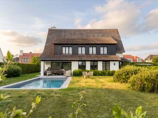 Au bout d'une impasse, à la lisière du Zoute, se trouve cette villa individuelle entièrement rénovée, sur un terrain de 988 m².<br /><br />On entre dans la villa par un vaste hall d'entrée doté d'un vestiaire et de toilettes pour invités. Le salon est très lumineux et s'ouvre entièrement sur le jardin orienté sud avec piscine.<br />La cuisine, dotée d’un coin petit-déjeuner, communique avec l’espace de vie et dispose d’une buanderie pratique.<br /><br />Au premier étage se trouve la chambre parentale avec sa salle de bains privative équipée d’une baignoire, d’une douche, d’un lavabo et de toilettes. Quatre chambres supplémentaires, chacune dotée de sa propre salle d’eau, complètent ce niveau. Le deuxième étage compte encore deux chambres à part entière avec une salle d’eau séparée.<br /><br />Au total, la villa dispose de sept chambres et de six salles de bains. Elle comprend également un garage intégré et de nombreuses places de stationnement sur la propriété.<br /><br />La villa a été récemment entièrement rénovée dans les règles de l'art, avec le souci du détail.<br /><br />Plus d'informations via Immo Nano, au 0471 22 68 18 ou sur info@immonano.be.