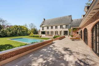 Een unieke kans voor wie op zoek is naar een uitzonderlijk afgewerkte klassewoning met zwembad, poolhouse/kantoor (ook apart toegankelijk) en dit op een strategische locatie. <br /><br />Deze Franse villa uit 1960 (architect Jules Delarue) werd in 2021 volledig en smaakvol gerenoveerd met respect voor haar karakter.<br /><br />De woning biedt lichtrijke, ruime leefruimtes en een open gevoel. Buiten geniet u van een aangelegde oprit in Belgisch porfier, parkeerruimte, garage, tuin met robotmaaier en ruime terrassen in oud marmer. Het zwembad (2021, Bob Monteyne) in lichtgrijze mozaïek is volledig uitgerust met automatisch onderhoud, rolluik met ledlamellen en onderwaterverlichting. Het poolhouse/kantoor met eiken kap, vloerverwarming en natuursteen is polyvalent in te richten.<br /><br />Indeling: inkomhal met originele marmeren vloer, houten trap en smeedijzerwerk, vestiaire en gastentoilet in marmer. Bureau met maatkasten en pivotdeur. Ruime leefruimte met haard, parket en sierlijsten. Luxe leefkeuken in natuursteen met vloerverwarming, Miele-toestellen, marmeren eiland met PITT-fornuis en ingewerkte audio. Aansluiting naar poolhouse. Domotica voor verwarming, verlichting en zwembad.<br /><br />De woning is volledig onderkelderd met o.a. wijnkelder, wasplaats, berging en mancave. Op de eerste verdieping: 4 slaapkamers met maatkasten, 3 marmeren badkamers en een dressing (25 m²). De tweede verdieping biedt 2 polyvalente ruimtes (bureau, speelkamer, extra kamers, cinemaruimte met airco) met douche en toilet.<br /><br />Extra: maatwerk (Interieur Projects), schilderwerken (Wouter Vanlerberghe), verlichting (Trizo), ramen (Pouleyn), alarmsysteem. Centrale verwarming op aardgas, dubbele beglazing, conforme elektriciteit.<br /><br />Een uitzonderlijke woning waar luxe, ruimte en afwerking samenkomen.