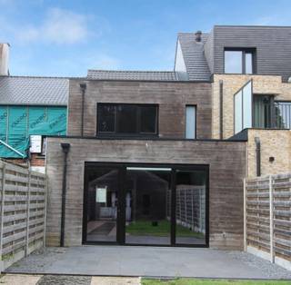 OPEN HUIS ZATERDAG 24 OKTOBER van 11u tot 12u ! Deze totaal gerenoveerde, smaakvol afgewerkte ruime stadswoning is met een gunstig E peil van 72 een top keuze als je op zoek bent naar een instapklare en energiezuinige woonst. Bovendien werd de woning mét vergunning en architectenplan verbouwd! Een mooie surplus voor de liefhebbers is het bijgebouw van ca 100 m²: zeldzaam, midden in de stad, en dan ook nog eens vergund! Hier kan je naar hartelust klussen, je hobby uitoefenen, je verzameling uitstallen, sporten... en / of de ruimte als opslag benutten. Deze ruimte vergt nog wel kluswerk ; ) (nieuw dak o.a., inrichten / afwerken). De woning is zeer gunstig ingedeeld. Ze bestaat uit een ruime inkomhal waar fietsen kunnen geplaatst worden. Naast de inkomhal is een ruimte met een raam dat uitkijkt op de straat. Dit kan je gebruiken als bureel of zelfs als fietsenberging als je (heel) veel fietsen hebt. Verder is er een wasplaats met uitgietbak, gastentoilet, de ruime woonkamer met zicht op de tuin achteraan, en met open ingerichte keuken met veel kasten, eiland, inductiekookplaat, ingebouwde koelkast, diepvriezer, vaatwasser en oven. De gebruikte materialen zijn stijlvol en gemakkelijk in het onderhoud (tegelvloeren in parketimitatie bv., composiet keukenblad,...). Op de verdieping vinden we 2 ruime slaapkamers en een ruime badkamer met inloopdouche, wastafel op karaktervol houten tablet en toilet. Op de tweede verdieping: derde slaapkamer of polyvalente ruimte. De woning geniet van veel lichtinval. Technisch: vloerverwarming, verluchtingssysteem, gunstig E peil. De gevel is nog verder esthetisch af te werken (bepleisteren, kaleien...). Toplocatie in het centrum, vlakbij de winkels, de markt, scholen, op 15 minuten wandelen van het station, op nog geen 10 minuten wandelen van het stadspark en de ring. Alle points of interest zijn op wandelafstand!