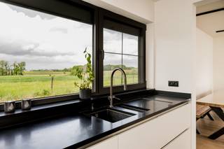 <p>Bent u op zoek naar een stijlvolle, perfect onderhouden woning met alle comfort? Dan zal deze instapklare gezinswoning u zeker weten te bekoren. Deze woning werd gebouwd in 2006 en kreeg in 2020 nog een smaakvolle renovatie van de bovenverdieping onder begeleiding van een binnenhuisarchitect, wat zorgt voor een moderne en warme uitstraling.</p>
<p>Bij het binnenkomen wordt u verwelkomd in een verzorgde inkomhal met een prachtige glazen deur (ANYWAY Doors) die toegang geeft tot de gezellige leefruimte. Deze staat in verbinding met het mooi terras achteraan en de tuin (9 aren). De volledig ingerichte keuken (Driesmans 2007) beschikt over alle nodige toestellen en een stijlvol granieten werkblad — ideaal voor wie graag kookt en geniet van een praktische keuken. Vanhieruit krijg je een vergezicht over de velden! De gelijkvloerse verdieping heeft vloerverwarming. Ook de wasplaats werd bijzonder functioneel ingericht met maatkasten, veel opbergruimte met mezzanine en een handige wastafel. Er is een dubbele garage met automatsiche toegangspoort.</p>
<p>Op de bovenverdieping bevinden zich drie volwaardige slaapkamers en een ingerichte bureauruimte, allemaal voorzien van laminaatvloeren.<br />De luxueus vernieuwde badkamer is een echte blikvanger met een ruime inloopdouche, een elegant badkamermeubel met dubbele wastafel en een grote spiegelwand. Een bergzolder bereikbaar via zolderluik</p>
<p>De woning heeft overal aluminium ramen met dubbele beglazing en rolluiken. <strong>Verwarming via warmtepomp. Er zijn ook zonnepanelen!</strong><br /><strong>EPC A, elektriciteit conform , de woning = future proof !!</strong></p>
<p>De ligging is bovendien uitstekend, met winkels, scholen en openbaar vervoer vlakbij. Een woning waar comfort, ruimte en kwaliteit perfect samenkomen. Zeker een bezoek waard!</p>