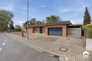<p><strong>Alleenstaande gelijkvloerse woning met 3slpk, dubbele garage en uitgestrekte tuin, gelegen in een groene omgeving.</strong></p><p>Deze open bebouwing biedt een rustige woonomgeving. Dankzij de gelijkvloerse indeling is het huis bijzonder praktisch en comfortabel. De ligging combineert het beste van twee werelden: nabij park, openbaar vervoer en invalswegen, maar toch in een serene woonkern.</p><p><br /></p><p>Bij het betreden van de woning komt u terecht in een ruime inkomhal met vestiaire en apart toilet. De <strong>gezellige woonkamer </strong>met zit- en eethoek (inclusief bar en bureel) en sfeervolle gashaard zorgt voor een warme sfeer, perfect voor knusse avonden. De woonkamer is voorzien van <strong>grote raampartijen</strong> die zorgen voor veel natuurlijke <strong>lichtinval</strong>. Aansluitend bevindt zich de ingerichte keuken uitgerust met alle comfort: vaatwasser, inductiekookplaat, oven, (combi-)microgolf en koelkast.</p><p>Daarnaast situeert zich een praktische wasplaats/ voorraadberging die toegang verleent tot de tuin, <strong>3 slaapkamers</strong> met maatwerk, badkamer met ligbad en douche. Een aanpalende <strong>dubbele garage</strong>, voorzien van een sectionale poort en tot slot is het eigendom <strong>volledig onderkelderd</strong>!</p><p><strong>De tuin </strong><span>vormt een oase van rust, privacy en ruimte. De afgesloten </span><strong>carport </strong><span>biedt extra opbergruimte voor tuinmateriaal, fietsen en/ of auto. </span></p><p><br /></p><p><strong>Neem vandaag nog contact op met je ERA-makelaar voor een bezoek.</strong></p><p><strong>JOUW DROOMHUIS. ZO GEVONDEN!</strong></p>