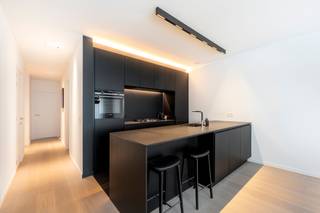 Gelegen in het gegeerde Mariaburg, bevindt zich dit modern en tot in de puntjes afgewerkt gelijkvloers appartement (bouwjaar 2020).<br /><br />Bij het binnenkomen valt meteen de kwalitatieve afwerking op. De inkomhal met vestiaire gaat naadloos over in een lichtrijke leefruimte waar maatwerk en strakke lijnen zorgen voor een rustig en coherent geheel. De geïntegreerde kastenwand biedt niet alleen extra opbergruimte, maar versterkt ook het architecturale karakter van het appartement.<br /><br />De open keuken met eiland vormt een echte eyecatcher en is volledig uitgerust met hoogwaardige toestellen, perfect voor gezellige avonden met vrienden en familie.<br /><br />Het appartement beschikt over een volwaardige master bedroom met ingemaakte kasten en een tweede kamer die perfect dienst kan doen als kinderkamer of bureau, eveneens voorzien van maatkasten. De badkamer is ruim en comfortabel ingericht met een ligbad, inloopdouche en een dubbel lavabomeubel.<br /><br />Via de leefruimte heb je directe toegang tot het zonnige terras en de privatieve zuidgerichte tuin, wat zorgt voor maximale lichtinval en een aangename buitenbeleving doorheen de dag. Op het terras is bovendien een automatische zonneluifel voorzien, waardoor je op elk moment comfortabel buiten kan zitten. De aanwezigheid van een achteruitgang maakt deze buitenruimte niet alleen aantrekkelijk, maar ook bijzonder praktisch in gebruik.<br /><br />Verder beschikt het appartement over een aparte berging met aansluiting voor wasmachine en droogkast. <br />In de kelderverdieping bevindt zich een kelderberging en een ondergrondse autostaanplaats die inbegrepen zijn in de prijs.<br /><br />Dankzij de recente bouw en de combinatie van vloerverwarming en parketvloeren geniet je hier van hedendaags comfort en een energiezuinige woonomgeving die volledig voldoet aan de huidige en toekomstige normen.<br /><br />Een instapklaar appartement waar afwerking, comfort en locatie perfect samenkomen.