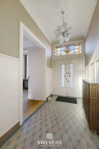 Voor meer info en foto’s, surf naar www.swevers.be – In het hart van Mol staat dit karaktervolle herenhuis uit 1933 met een bewoonbare oppervlakte van 269 m², verdeeld over drie verdiepingen. De woning biedt zes slaapkamers, twee badkamers en tal van authentieke elementen, gecombineerd met modern comfort zoals zonnepanelen, airco en een recente gasketel (2021). Op het gelijkvloers vind je een zeer ruime leefruimte opgedeeld in een voorkamer, centrale zithoek en eetkamer, gevolgd door een keuken met berging, apart gastentoilet en een inpandige stadsgarage. Het zuidgerichte perceel van 3a30ca beschikt over een onderhoudsvriendelijk overdekt terras en is verder momenteel ingericht als basketpleintje maar perfect om te vormen tot een knusse stadstuin. Dankzij de centrale ligging op wandelafstand van winkels, scholen, horeca en openbaar vervoer is dit pand ideaal voor gezinnen of wie ruimte zoekt voor werk of hobby’s. Extra troeven zijn de kelder van 45 m² en parkeermogelijkheid op de oprit of in de straat. Voor meer informatie, bel 011 255 155. Bron bewoonbare oppervlakte: EPC – verslag.