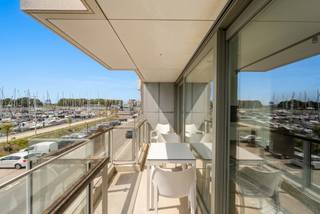 Modern appartement met twee slaapkamers en prachtig zicht op de jachthaven van Zeebrugge. Een topligging waar comfort en het ultieme kustgevoel samenkomen.
Via de inkomhal komt u in de ruime en lichtrijke leefruimte met halfopen, volledig uitgeruste keuken. De vele ingemaakte kasten zorgen voor extra comfort en een optimale benutting van de ruimte. Aansluitend bevindt zich een praktische berging.
Vanuit de leefruimte heeft u toegang tot het ruime zuidwestgerichte terras, waar u geniet van een adembenemend zicht op de jachthaven. De ideale plek om te ontspannen en elke dag van het vakantiegevoel te genieten.
Het appartement beschikt verder over twee volwaardige slaapkamers, een ruime badkamer, een apart toilet en een tweede berging die eventueel kan worden ingericht als extra douchekamer.
In de kelder beschikt u over een private kelderberging. Daarnaast is er de mogelijkheid om een afgesloten garagebox in de residentie aan te kopen.
Een bijzonder aantrekkelijk appartement voor wie op zoek is naar comfort, ruimte en een unieke ligging aan zee – ideaal als vaste woonst, tweede verblijf of investering.
Voor meer informatie of een bezoek kunt u contact opnemen met makelaar Stéphanie via 0472 77 86 60 of stephanie@keyimmo.be.
