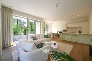 Dit appartement op de eerste verdieping heeft een bewoonbare oppervlakte van 95 m² beschikt over een lichtrijke eet- en leefruimte, een open keuken, een praktische berging en 2 slaapkamers. Verder vindt men er een gastentoilet en een badkamer met een dubbele lavabo en een inloopdouche of ligbad. Langs de voorzijde situeert zich een terras van 15 m² met zuid-oostelijke oriëntatie. Aan de achterzijde beschikken de slaapkamers over een tweede terras van 10 m².<br /><br />Bloei is een duurzaam nieuwbouwproject ingeplant in een groene omgeving tussen het Vossenbos en een nieuw park en dit op 7 minuten fietsen van Station Gent Sint-Pieters en op wandelafstand van de tramhalte van lijn 1.<br /><br />De zes kleinschalige gebouwen omvatten een mix van zowel 1, 2, 3 als 4 slaapkamers en werden getekend door 3 ervaren architectenbureaus waarbij sterk werd ingezet op een doordachte indeling, maximale lichtinval en zonneterrassen. <br /><br />Bewoners van Bloei kunnen genieten van een hoog-efficiënte warmtepomp in combinatie met zonnepanelen, akoestische en thermische isolatie, resulterend in een E-peil lager dan E22, wat tal van voordelen biedt voor zowel uw maandelijkse energiefactuur als uw persoonlijk comfort. <br /><br />Benieuwd naar het nieuwbouwproject Bloei? Wij ontvangen je graag voor een persoonlijke en vrijblijvende kennismaking.