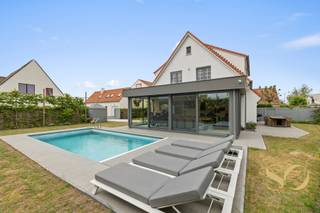 <p>We stellen u graag deze uitzonderlijke woning voor, discreet gelegen aan de Natiënlaan 229 in Knokke. In tegenstelling tot de meeste panden langs deze verbindingsweg, bevindt deze villa zich iets achterin, waardoor u geniet van een aangename rust en volledige privacy. Deze volledig gerenoveerde luxewoning combineert stijl, comfort en functionaliteit op een uitmuntende locatie aan de Belgische kust. De ruime en lichtrijke woonkamer vormt het hart van de woning en sluit naadloos aan op een volledig ingerichte Amerikaanse keuken, uitgerust met hoogwaardige toestellen en een professionele teppanyakki-plaat. Een afzonderlijk bureau biedt ruimte voor thuiswerk of kan perfect dienstdoen als 4de slaapkamer. Op de eerste verdieping bevinden zich drie volwaardige slaapkamers, een dressing en twee moderne badkamers. De woning werd volledig gerenoveerd met oog voor detail en duurzame materialen. Het dak werd recent geïsoleerd en vernieuwd en er werden zonnepanelen geplaatst met batterij. Efficiënte en energiezuinige verwarming door recente gasketel en warmtepomp. EPC: B. Oostgericht terras en een zuidelijk georiënteerd, verwarmd zwembad dat recent werd uitgerust met een nieuwe elektrische rolluik. De mooi onderhouden tuin beschikt bovendien over twee praktische tuinhuizen. Voor uw wagens is er zowel een inpandige garage als een carport voorzien. Deze instapklare woning biedt het beste van twee werelden: rust en discretie, vlak bij het centrum van Knokke (10min met de fiets). </p>