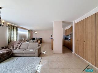 In het hart van Zedelgem, op wandelafstand van winkels, openbaar vervoer en horeca, vind je dit ruime en verzorgde appartement op het gelijkvloers van een gebouw dat werd gebouwd in 2003. Bij het binnenkomen kom je terecht in een ruime inkomhal die overvloeit in de nachthal. De lichtrijke woonkamer biedt plaats aan een gezellig zit- en eetgedeelte en sluit mooi aan bij de open, hyper-geïnstalleerde keuken die voorzien is van alle comfort. Aansluitend is er een praktische berging met aansluiting voor wasmachine. Via de nachthal bereik je de twee volwaardige slaapkamers, een apart gastentoilet en de badkamer. In de badkamer heb je een lavabomeubel met dubbele lavabo en een douche. In de kelderverdieping van het gebouw bevindt zich een garage die voorzien is van elektriciteit. Deze garage is bereikbaar via de achtergelegen garagewegel met uitweg naar de Loppemsestraat. Een instapklaar appartement met een ideale ligging voor wie centraal, comfortabel en praktisch wil wonen in Zedelgem. (sted. inl.: in aanvraag)