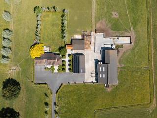 <p>Op een <strong>uitzonderlijke topligging aan de flanken van de Oedelemberg</strong> ontvouwt zich deze karaktervolle boerderij, omgeven door uitgestrekte weides en pure natuur. Hier ervaar je een <strong>zeldzame combinatie van open vergezichten, absolute rust en maximale privacy</strong>, op een perceel van maar liefst <strong>1,5 hectare</strong>. Een plek waar stilte, ruimte en authenticiteit samenkomen.</p>
<p>De woning zelf imponeert door haar <strong>royale volumes en doordachte indeling</strong>. Via de inkomhal krijg je toegang tot enerzijds een ruime leefruimte en anderzijds een afzonderlijk bureau, ideaal voor thuiswerk of een vrij beroep. De leefruimte sluit naadloos aan op de bijzonder grote keuken, die uitgroeit tot het hart van het huis. Hier vind je niet alleen een gezellige ontbijthoek, maar ook een extra zithoek, een praktische berging en een volwaardige bijkeuken. Grote raampartijen zorgen voor een <strong>adembenemend uitzicht op de tuin en de omliggende weilanden</strong>, dat nooit verveelt.</p>
<p>Op het gelijkvloers is verder een badkamer voorzien, een tweede inkom met gastentoilet, een zeer ruime was- en technische ruimte én een dubbele inpandige garage. Alles is opgevat met het oog op comfort en functionaliteit.</p>
<p>De verdieping biedt plaats aan <strong>drie uitzonderlijk ruime slaapkamers</strong> en een grote badkamer. Dankzij de overvloedige ruimte zijn hier moeiteloos <strong>extra slaapkamers of badkamers</strong> te realiseren, volledig naar eigen wens.</p>
<p>Het erf omvat daarnaast meerdere <strong>solide bijgebouwen en stallen</strong> met oppervlaktes van ongeveer 600 m², 250 m² en 175 m², aangevuld met een <strong>vergunde mestput</strong>. De eigendom wordt vandaag nog uitgebaat als agrarisch bedrijf (rundveehouderij) en beschikt over de nodige vergunningen. Gelegen in <strong>landschappelijk waardevol agrarisch gebied</strong>, zonder opname op erfgoedlijsten, biedt dit pand tal van mogelijkheden.</p>
<p>Verder beschikt het geheel over <strong>duurzame voorzieningen</strong>, waaronder twee regenwaterputten van 5.000 liter, een gemetste waterput met pomp en <strong>meer dan 60 zonnepanelen</strong> op de stal naast de woning.</p>
<p>Voor wie nóg meer ruimte wenst, bestaat de mogelijkheid om de <strong>aangrenzende weilanden aan te kopen</strong>, goed voor een totale oppervlakte van <strong>6,28 hectare</strong>.</p>
<p>Een <strong>unieke eigendom</strong> voor wie groots wil wonen, werken of ondernemen, midden in het groen en ver weg van de drukte.</p>
<p>Voor meer informatie of het inplannen van een bezoek, aarzel niet om ons te contacteren via info@bonnevastgoed.be of via 050/73.73.73.</p>
