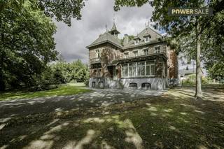 Bent u op zoek naar een historisch pareltje met een unieke uitstraling? Deze statige villa in Anzegem, gebouwd rond 1900 in opdracht van dokter Vancauwenberghe, combineert authentieke charme met opvallende architectuur. <br /><br />De woning ligt wat dieper op het perceel, wat zorgt voor een aangename privacy, en is aan de straatzijde stijlvol afgesloten met een bakstenen muurtje en een sierlijk ijzeren hekwerk.<br /><br />De beeldbepalende woning betreft een eclectisch dubbelhuis met duidelijke invloeden uit de neo-Vlaams-renaissance. Dat uit zich onder meer in de karakteristieke puntgevel, het sierlijke torentje aan de westzijde en het verfijnde gebruik van hoogwaardige bouwmaterialen. De gevel van rode baksteen is verfraaid met siermetselwerk van geglazuurde accenten en zwarte bakstenen ruitmotieven. Daarnaast is er rijkelijk gebruikgemaakt van blauwe hardsteen (arduin) voor het bordes, de hoekblokken, tussenstijlen, aanzet- en dekstenen. Het leien dak is voorzien van twee dakkapellen en wordt bekroond door sierlijke bliksemafleiders.<br /><br />Ook de gevelindeling en het gedetailleerde houtwerk springen meteen in het oog. De vooruitspringende deurtravee en de brede venstertravee worden geaccentueerd door een klassiek bow window op het gelijkvloers en een driedelige houten erker op de eerste verdieping. Alle getoogde raam- en deuropeningen beschikken bovendien over bewaard gebleven authentiek schrijnwerk. Naast de villa bevindt zich een ruime garage die volledig in dezelfde architecturale stijl werd opgetrokken. Deze beschikt over twee poorten — waarvan één vernieuwd — onder robuuste ijzeren I-balken, wat het geheel op esthetisch vlak prachtig compleet maakt.<br /><br />INDELING<br />- Inkomhal, riante leefruimtes, ruime keuken, bureau, praktijkruimte <br />- 9 slaapkamers<br />- Volledig onderkelderd<br />- Terras - ruime tuin - koetshuis - garage<br /><br />Deze eigendom wordt aangeboden via het power-sale concept die loopt tot en met 23 oktober.<br /><br />Wenst u dit uitzonderlijke vastgoed in Anzegem te ontdekken? Neem dan contact op met Matisse Vandererven (0472/186420) of Carl Boedts (0473/951821) voor meer informatie of een bezoek.<br /><br /><br /><br />Bestuursmaatregelen in het maatregelenregister: nee