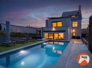 <span>BEZOEKDAG VRIJDAG 12/06 VAN 17U TOT 19U!</span><br /><br /><span>WELLE - Niemand vermoedt achter deze charmante herenwoning de moderne leefwereld die zich achteraan volledig ontvouwt.</span><br /><br /><span>Achter de gevel van deze herenwoning schuilt een uitzonderlijke residentie waar charme en hedendaagse architectuur elkaar perfect versterken.</span><br /><span>De woning onderging een totaalrenovatie van hoog niveau waarbij authenticiteit, ruimtegevoel en moderne luxe centraal staan. De combinatie van de karaktervolle herenwoning met de strakke moderne uitbreiding creëert een unieke woonbeleving waar licht, comfort en verfijning samenkomen.</span><br /><br /><span>De leefruimtes baden in natuurlijk licht dankzij glaspartijen die een naadloze connectie vormen met de tuin, de terrassen en het stijlvolle zwembad. De volledig uitgeruste leefkeuken met hoogwaardige Bosch-toestellen vormt het hart van de woning en combineert functionaliteit met elegant design.</span><br /><br /><span>Met vier volwaardige slaapkamers, twee stijlvolle badkamers, een afgewerkte zolderverdieping, een ruime berging en technische ruimte biedt deze residentie uitzonderlijk veel leefruimte voor gezinnen die comfort en uitstraling wensen te combineren.</span><br /><br /><span>Buiten werd dezelfde aandacht voor detail doorgetrokken. De uitgestrekte tuin vormt samen met het stijlvolle zwembad, het poolhouse met douche en toilet, de jacuzzi en de sfeervolle overkapping een aangename buitenomgeving waar het buitenleven centraal staan.</span><br /><br /><span>Het royale perceel van 44 are biedt bovendien een zeldzame vrijheid en tal van mogelijkheden. Of het nu gaat om speelruimte voor kinderen, het houden van dieren, extra tuinbeleving of simpelweg genieten — deze eigendom combineert exclusief wonen met een uitzonderlijk gevoel van openheid en ruimte.</span><br /><br /><span>Ook technisch bevindt deze eigendom zich op topniveau. De woning is uitgerust met een warmtepomp, vloerverwarming, airconditioning op de slaapkamers, laadpaal, alarmsysteem, camerabewaking, 54 zonnepanelen en een thuisbatterij van 25 kW. Dankzij het uitzonderlijke E-peil van -20 geniet u bovendien gedurende vijf jaar van vrijstelling van het kadastraal inkomen.</span><br /><span>Bovendien is er een vlotte verbinding naar de E40, het station, scholen en winkels, bereikbaar binnen enkele minuten.</span><br /><br /><span>Een unieke residentie voor wie compromisloos wil wonen in een woning waar authenticiteit, technologie en buitenbeleving perfect samensmelten.</span><br /><span>Bieden vanaf 749.000€</span><br /><br /><span>Meer info of bezoek: 053/60.65.60</span>