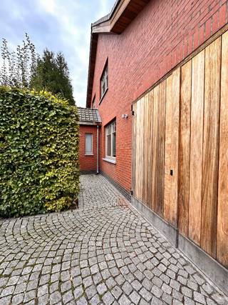 Instapklare open bebouwing met EPC A, 180 m² bewoonbare oppervlakte en zonnige tuin
Deze woning uit 1958 werd gerenoveerd naar de hedendaagse standaard met oog voor energie en kwaliteit
Het gelijkvloers biedt een ruime en lichtrijke leefruimte van ongeveer 70 m², waar woonkamer, eetkamer en keuken in een U-vorm rond de traphal werden gebouwd. Grote raampartijen zorgen voor een overvloed aan natuurlijk licht en een mooi zicht op het omliggende groen.
De moderne keuken is uitgerust met kwalitatieve AEG-toestellen, waaronder een stoomcombi-oven, combi-microgolfoven, inductiekookplaat, koelkast, vaatwasser en Quooker.
Op de verdieping bevinden zich twee ruime slaapkamers, een bureauruimte en een recent vernieuwde badkamer met inloopdouche, dubbele lavabo en toilet. Via een trap in de bureelruimte bereik je de zolderverdieping, die dankzij twee grote dakramen werd ingericht als een volwaardige slaapkamer van circa 23 m².
Extra comfort wordt geboden door airconditioning in de leefruimte en slaapkamers, HR++-beglazing, een ventilatiesysteem en zonnepanelen. De woning behaalt hierdoor een uitstekend EPC A-label.
Buiten geniet je van een perceel van 510 m² met een zonnige zuidwestgerichte tuin, veel privacy en een ruim terras van ongeveer 35 m². De volwassen tuin zorgt voor een aangenaam klimaat.
Verder beschikt de woning over een inpandige garage, parkeerplaats voor twee wagens op eigen terrein, een praktische wasplaats van 12 m² en een droge kelder.
De ligging vormt een extra troef: openbaar vervoer, scholen, winkels en het ziekenhuis bevinden zich allemaal op wandelafstand.