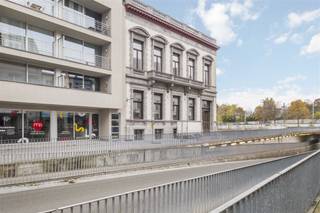 Gelegen in het hart van Kortrijk, biedt dit indrukwekkende kantoorpand een royale bruikbare oppervlakte van 456,7 m². Het historische karakter van het gebouw wordt op elegante wijze gecombineerd met moderne functionaliteiten, waardoor het een ideale werkplek is.Bij binnenkomst valt meteen de ruime en goed verlichte receptie op, perfect om gasten te ontvangen. De majestueuze houten trappen geven het interieur een klassieke uitstraling en leiden naar verschillende kantoorruimtes. Deze ruimtes zijn voorzien van hoge plafonds en grote ramen, wat zorgt voor een aangename en lichte werksfeer.Het pand beschikt over meerdere stijlvolle vergaderruimtes, elk met een uniek karakter. De parketvloeren en verfijnde afwerking benadrukken de kwaliteit en klasse van het gebouw. Daarnaast zijn er voldoende sanitaire voorzieningen aanwezig voor het comfort van uw team en bezoekers.Dankzij zijn centrale ligging in Kortrijk is het pand uitstekend bereikbaar, zowel met de auto als met het openbaar vervoer. Diverse parkeermogelijkheden in de nabijheid maken het extra toegankelijk.Dit pand is de perfecte keuze voor bedrijven die op zoek zijn naar een prestigieuze locatie met een authentieke uitstraling. Mis deze unieke kans niet om uw bedrijf naar een hoger niveau te tillen in een van de meest opmerkelijke kantoorgebouwen van Kortrijk.