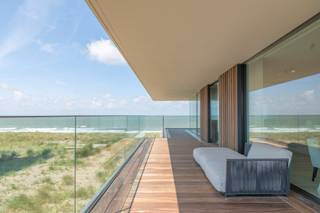 In het prestigieuze project De Blanke Top – The Residence in Cadzand-Bad bevindt zich dit uitzonderlijke hoekappartement met zeezicht en zicht over de polders, royaal terras rondom.<br /><br />Het appartement ligt op de eerste verdieping van toren Zeeland en maakt deel uit van een architecturaal geheel dat perfect geïntegreerd is in het duinlandschap. <br /><br />Indeling:<br />Via de stijlvolle inkomhal en lift met individuele toegangscode bereikt u het appartement. De leefruimte ademt luxe, licht en openheid, met grote Sky-Frame schuifpuien die binnen en buiten naadloos verbinden.<br /><br />De ruime woonkamer, eetplaats en maatwerkkeuken vormen één harmonieus geheel. De keuken is uitgerust met hoogwaardige Gaggenau-toestellen en een groot kookeiland, telkens met prachtig zicht op zee en omgeving.<br /><br />Het appartement beschikt over drie ruime slaapkamers, elk met maatwerkkasten en een verfijnde hoteluitstraling. De master bedroom bevindt zich aan de zeezijde en beschikt over een luxueuze badkamer. De overige slaapkamers zijn eveneens ruim en stijlvol afgewerkt.<br /><br />Terras:<br />Het royale terras loopt rondom het appartement en is bereikbaar vanuit de leefruimte, keuken en slaapkamers. Van hieruit geniet u van zeezicht en een panoramisch zicht over Cadzand-Bad.<br /><br />Bijzonderheden:<br />- Zeezicht en panoramisch zicht over Cadzand-Bad<br />- Royaal terras rondom het appartement<br />- Luxe maatwerkkeuken met Gaggenau-toestellen<br />- Grote Sky-Frame schuifpuien<br />- Hoogwaardige afwerking met accenten van Vincent Van Duysen<br />- Inclusief berging, parkeerplaats en afgesloten garageboxen<br />- Vraagprijs exclusief 21% btw, ten laste van de koper
