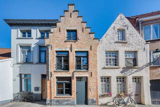 Brugge centrum, in charmante rustige straat ,op wandelafstand van alle winkels, tussen 't Zand en de Markt.<br /><strong><u>NETTE KARAKTERVOLLE KNUSSE STADSWONING met patio en 2 slaapkamers. IDEAAL OM TE VERHUREN CONFORMITEITSATTEST BESCHIKBAAR</u></strong><br /><br />Inkom, rustieke ingebouwde keuken met eiken deurtjes en groot retro gasfornuis, gezellige living, stadsterras, badkamer met douche, lavabo, toilet.<br />Open trap naar de 1é verdieping , waar prachtige kamer met eiken plankenvloeren, toilet, open trap naar de dakverdieping waar prachtig met hout afgewerkte kamer.<br />Prachtig rustiek gerestaureerd ! EIKEN  balkenplafonds, warme  plankenvloeren, eiken deuren, franse witsteen, muren in Brugse moefenmix met kleine NISJES in de muren gemetst.        Voor de LIEFHEBBER !   Uniek  !<br /><br />Dubbel glas, centrale verwarming op aardgas, goed geïsoleerd.