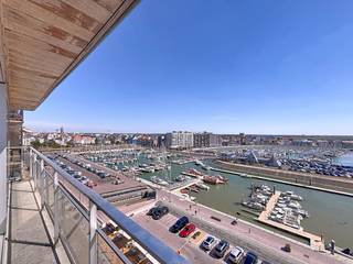 Appartement te koop te Blankenberge met panoramisch zicht op de jachthaven en het hinterland.De ruime leefruimte met veel lichtinval en ingemaakte kasten geeft toegang tot een zonnig balkon. De keuken is uitgerust met kwalitatieve toestellen: keramische kookplaat, combi-oven, vaatwasser, dampkap en koelkast met diepvries. Er zijn 2 slaapkamers met ingebouwde kasten, een 3e kamer als berging, dressing of kinderkamer en een extra terras achteraan. De badkamer beschikt over bad/douche, lavabomeubel, hangtoilet en wasmachine-aansluiting. Afzonderlijk gastentoilet en extra berging aanwezig. Het appartement is instapklaar, kan gemeubileerd gekocht worden, en heeft tijdloze vloertegels, HR-glas, condenserende gasketel en EPC-label B. Gemeenschappelijke fietsenstalling, slechts 1 appartement per verdieping. De achtergevel en dak werden recent vernieuwd, alsook de koud waterleidingen en CV leidingen.Wens je meer informatie of een bezoek aan dit appartement te koop? Contacteer dan Céline Desmet op het nummer 0472 18 38 50 of per mail via celine.desmet@dewaele.com